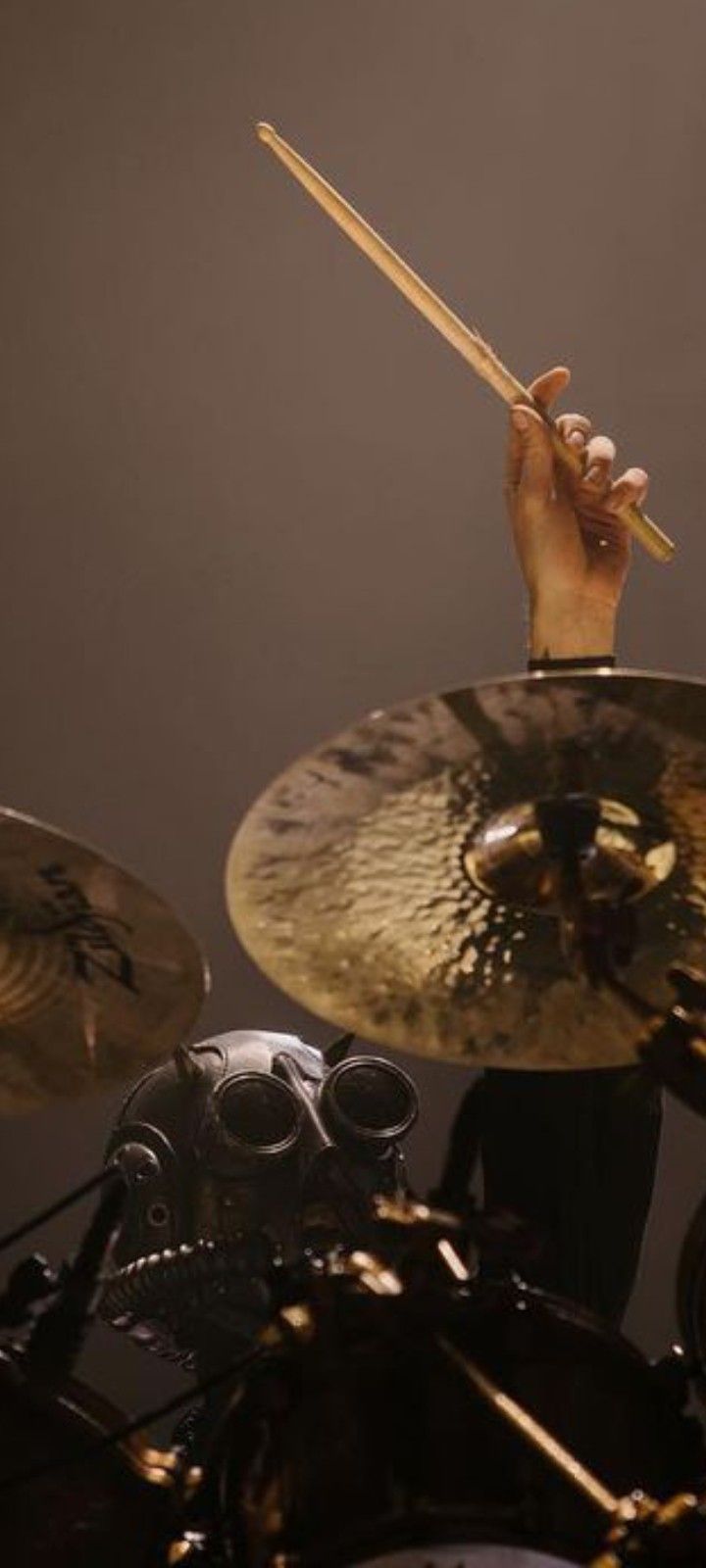 a man playing drums on stage with his hands up to the drum sticks in front of him