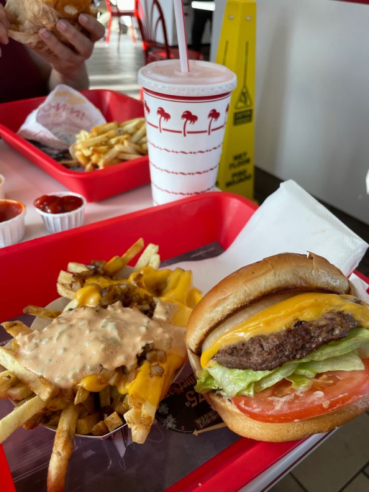 a hamburger and fries are sitting on a tray at a fast food restaurant, ready to be eaten