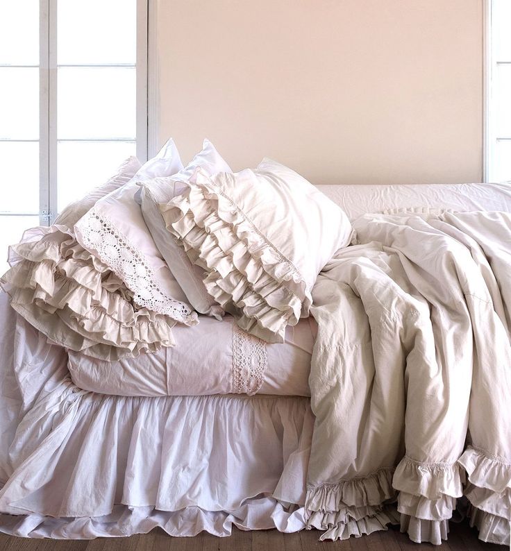 an unmade bed with ruffled sheets and pillows