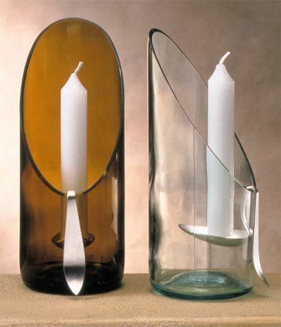 two glass vases with candles in them sitting next to each other