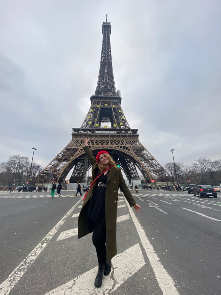 a woman standing in front of the eiffel tower