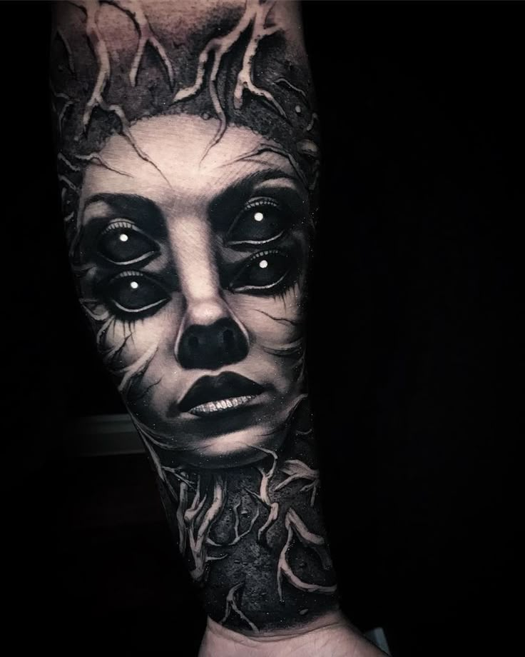 a man's arm with a black and white tattoo design on it, depicting the face of a woman