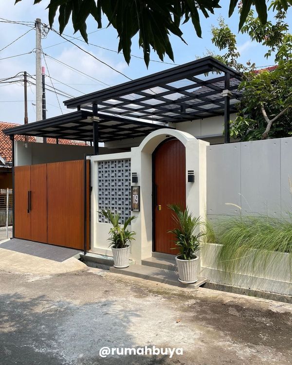 a white house with wooden doors and plants