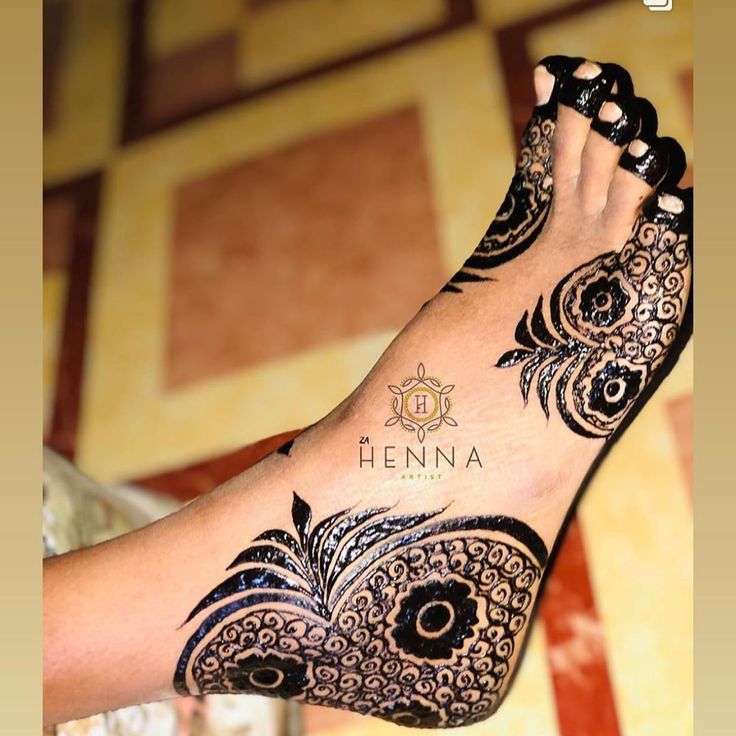 a woman's foot with henna tattoos on it and the words henna written in black ink