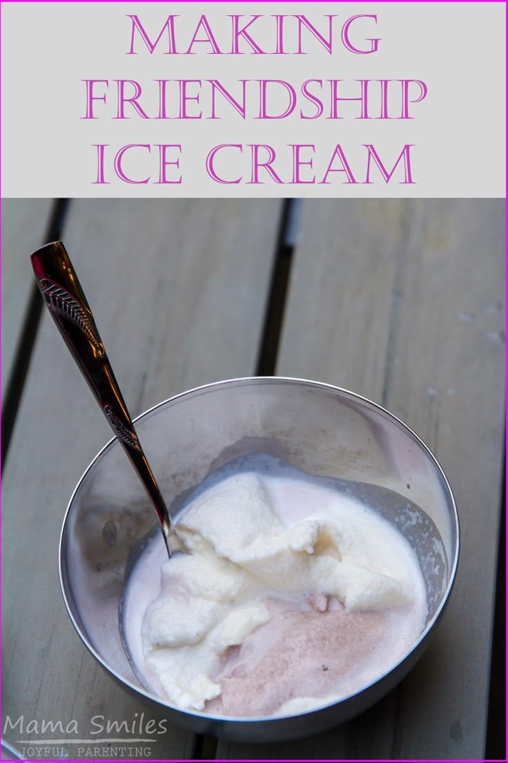 a bowl filled with ice cream sitting on top of a wooden table next to a spoon