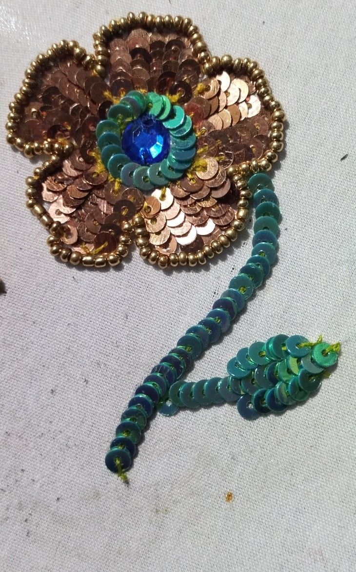 a brooch that is laying on the ground next to some beads and other things