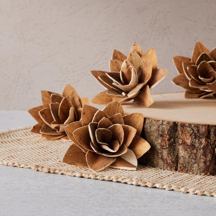 some paper flowers are sitting on top of a piece of burlocked wood