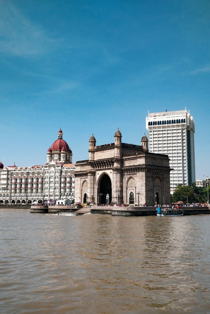 a large building sitting on top of a river next to tall buildings