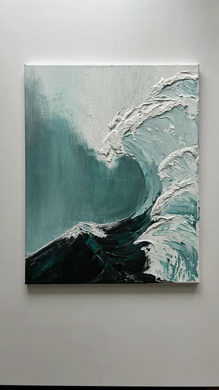 a painting on the wall with waves in blue and white colors is hanging up against a gray wall