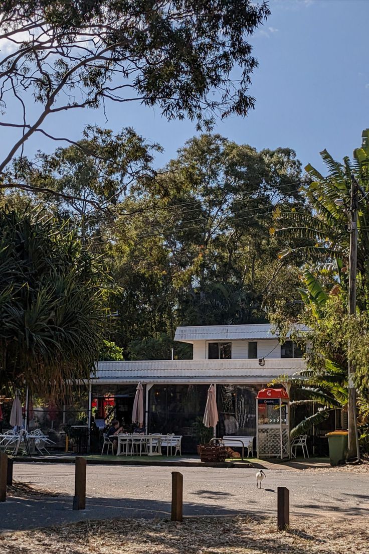 a small white house sitting in the middle of a forest