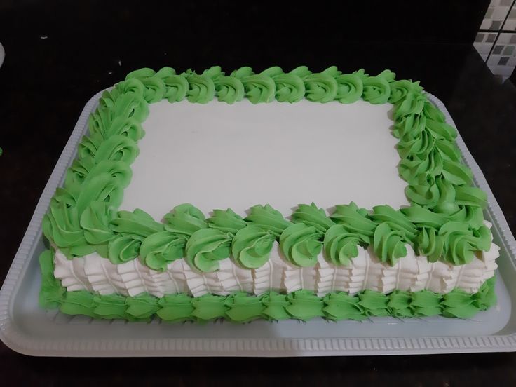 a green and white cake sitting on top of a plastic tray covered in icing