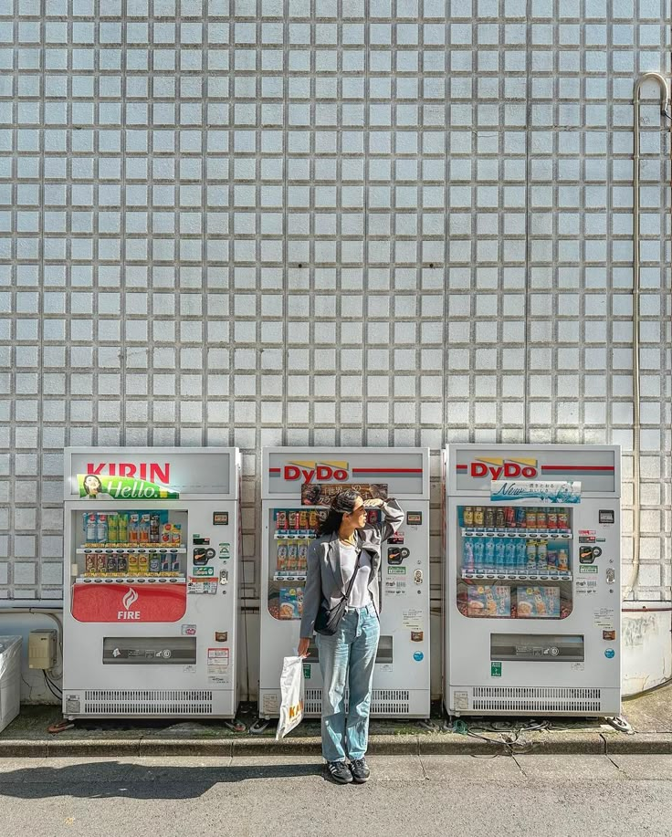 a woman standing next to two vending machines