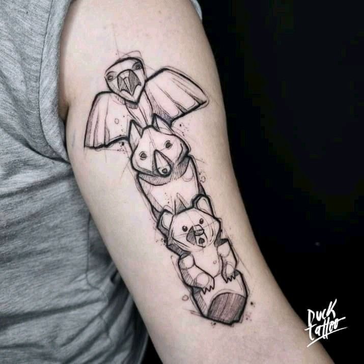 a woman with a tattoo on her arm has an owl and bear in the shape of a rocket ship