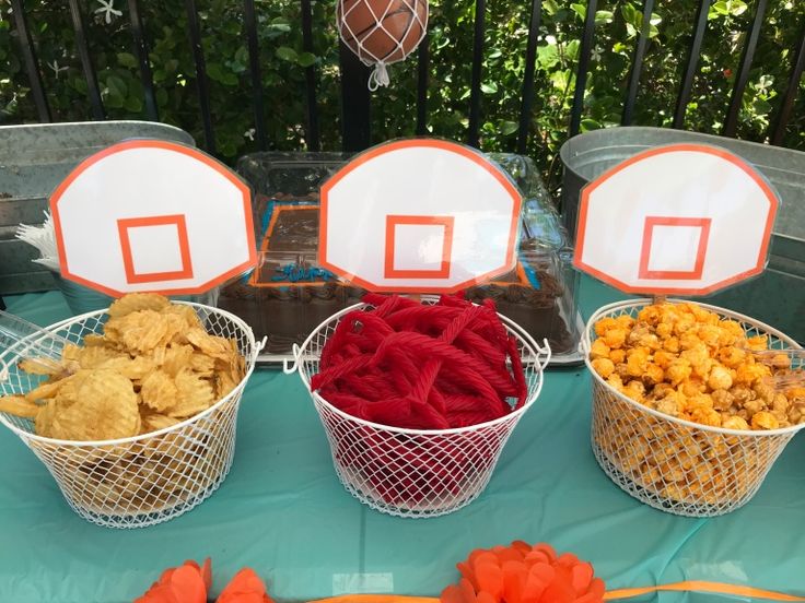 three baskets filled with snacks sitting on top of a table next to plates and bowls