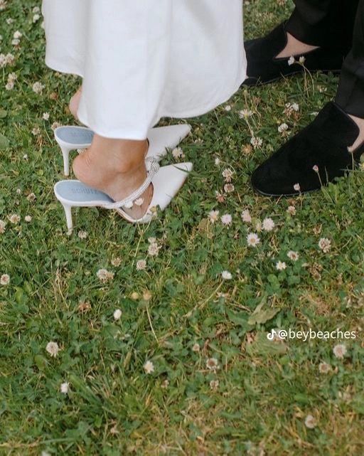 the bride and groom's shoes are on their feet as they stand in the grass