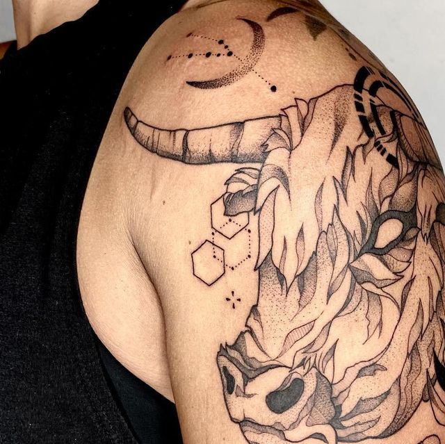 a man with a bull tattoo on his shoulder