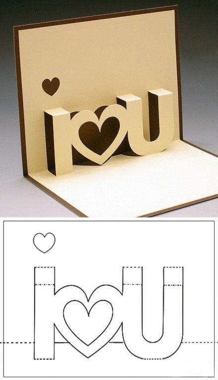 an open card with the word i love you cut out of paper and two hearts