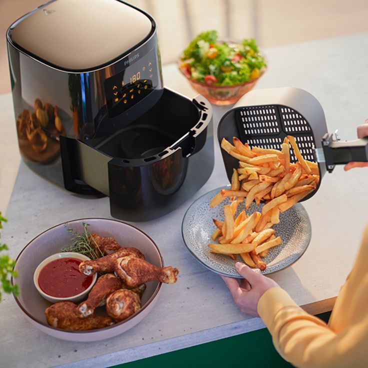 a person is using an air fryer to cook french fries