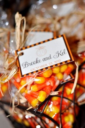 a basket filled with candy corn on top of a table next to a sign that says brooke and kell