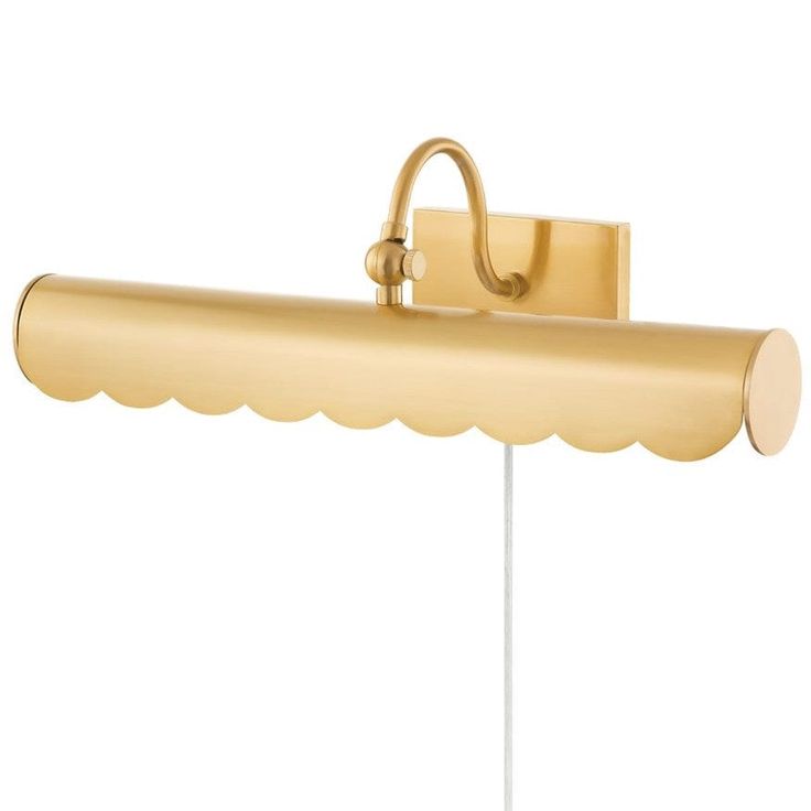 a gold wall light with a scalloped shade on the side and a white base