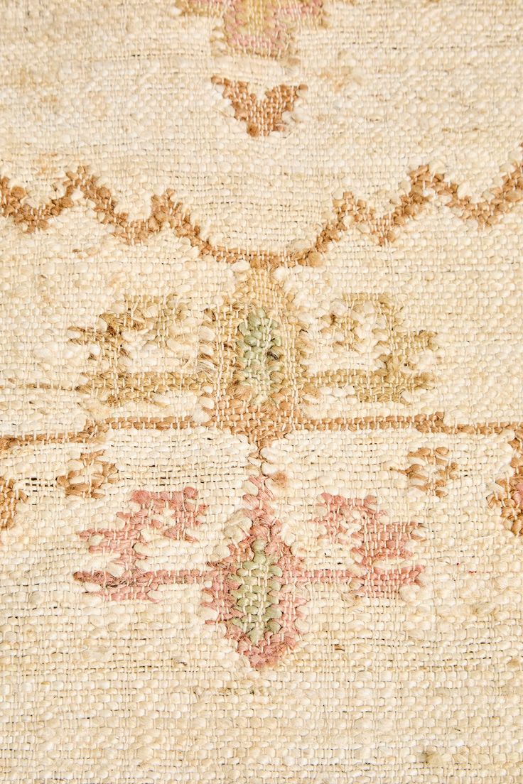 an old rug with many different colors and designs on the carpet, including pinks