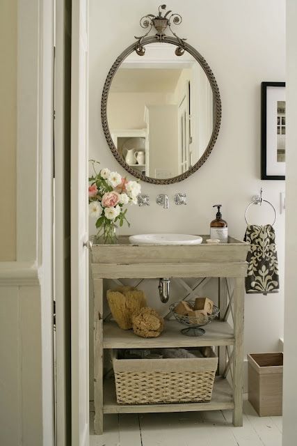 a bathroom with a sink, mirror and shelves on the wall next to an open door