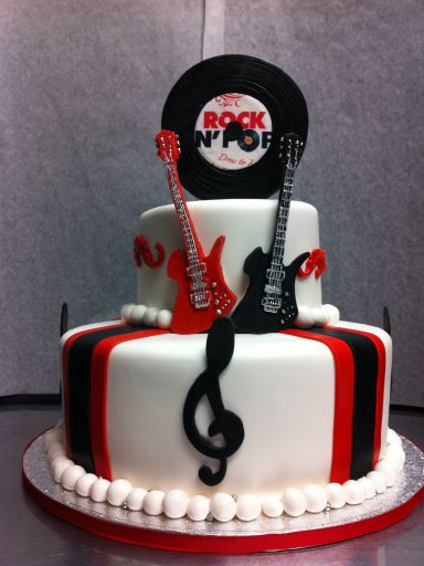 a cake decorated to look like a rock and roll with guitar, record player, and amp on top