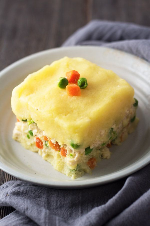 a piece of cake on a white plate with peas and carrots in the middle