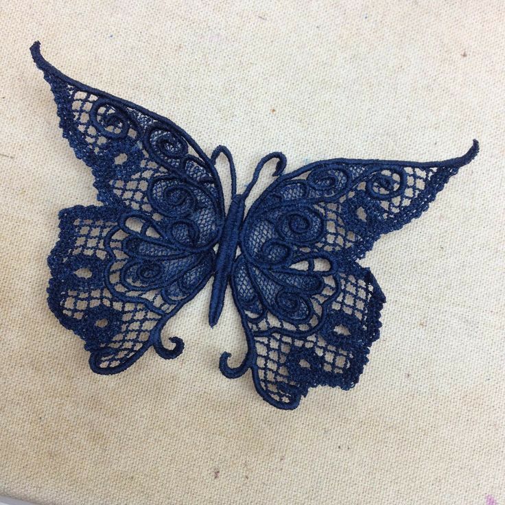 a blue lace butterfly sitting on top of a piece of cloth