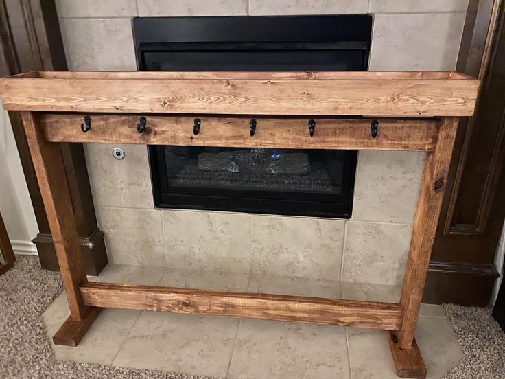 a wooden fireplace mantel with a tv above it