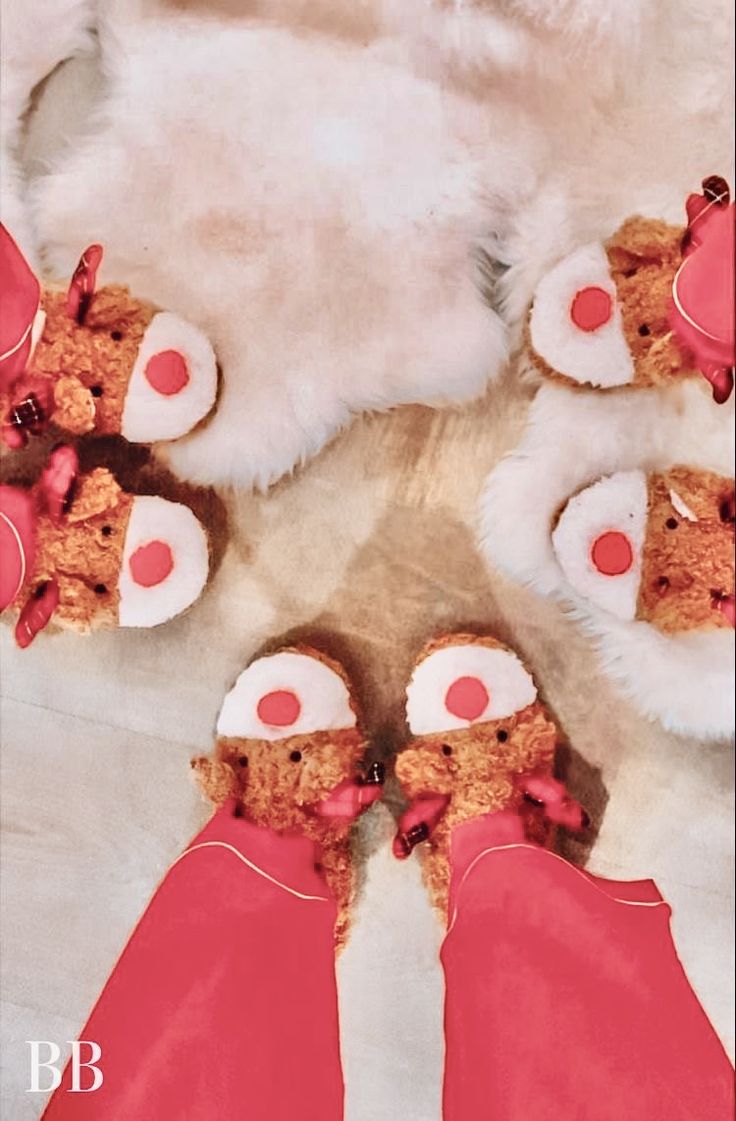 teddy bears are arranged in the shape of a heart on a white fur rug with pink and red accents