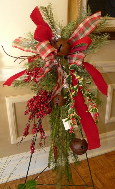 a christmas wreath with holly, pine cones and bells