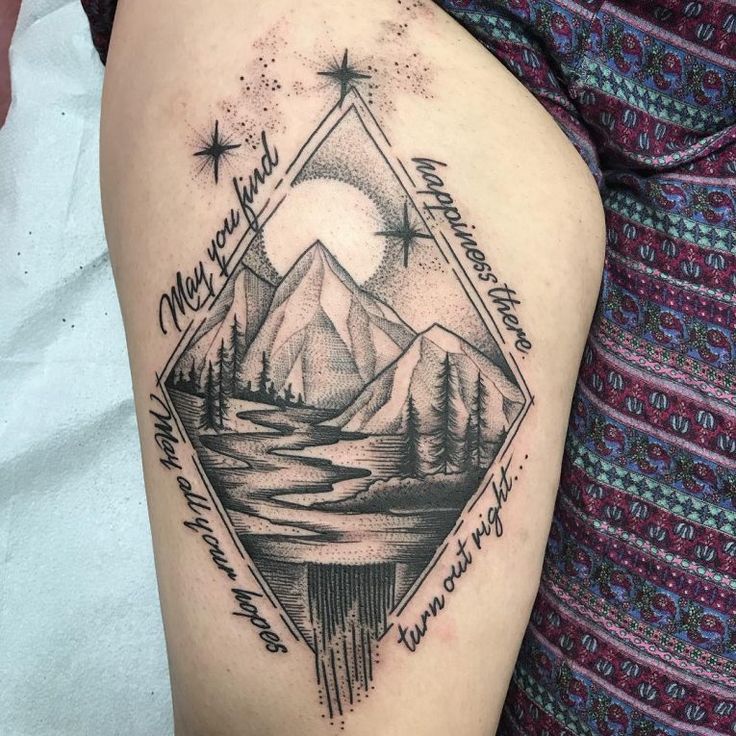 a tattoo with mountains and trees on it