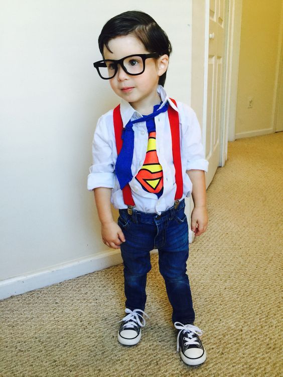 a young boy wearing glasses and a superman tie