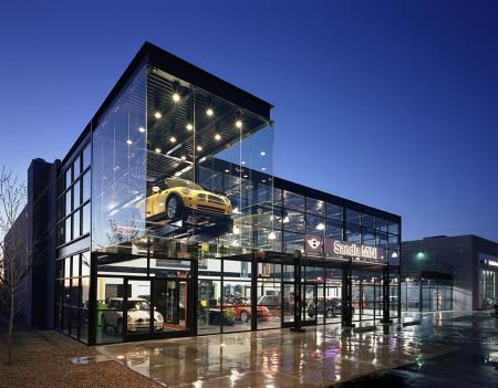 a car dealership at night with the lights on