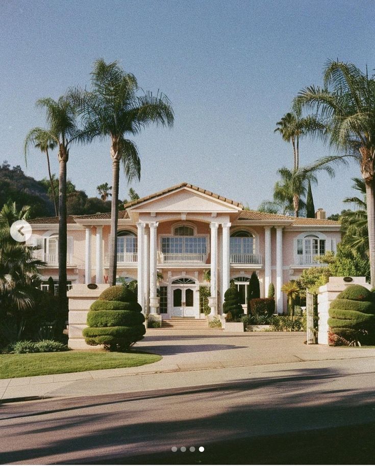 a large house with palm trees in front of it