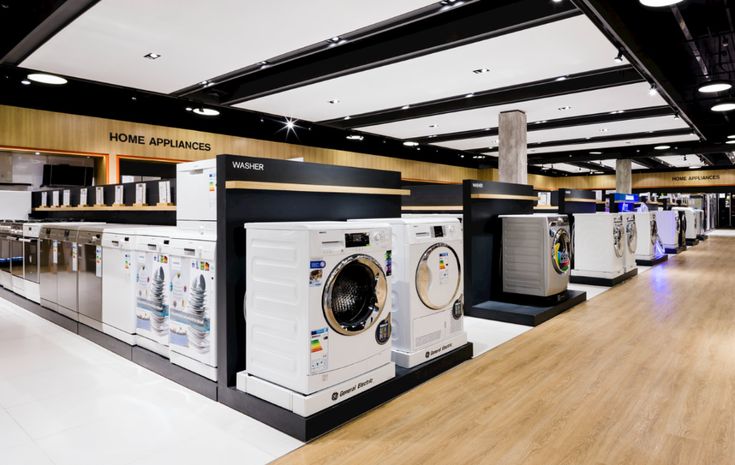 several washers and dryers are on display in a large room with wood flooring