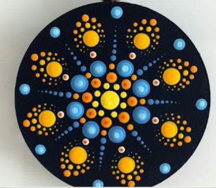 a black and yellow circular object with circles on the center, surrounded by small dots