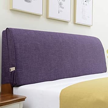 a purple headboard on a bed in a room with pictures hanging above the bed