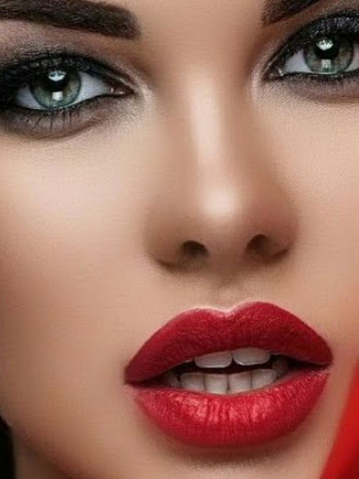 a woman with red lipstick and green eyes