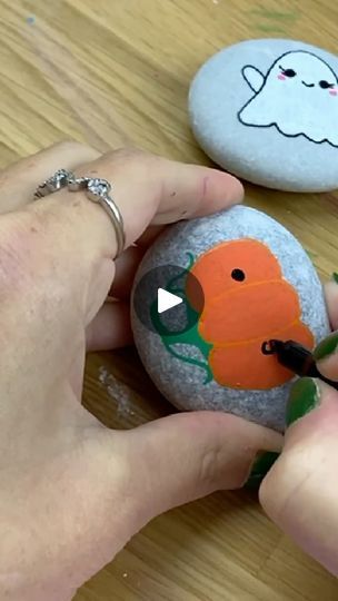 someone is painting some rocks with halloween decorations on them, and then they are painted to look like pumpkins