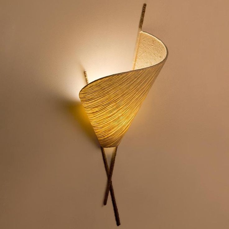 a wall mounted lamp with two sticks sticking out of it's center and one light on the other side