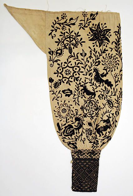 an old piece of cloth that has been decorated with flowers and birds in black on beige