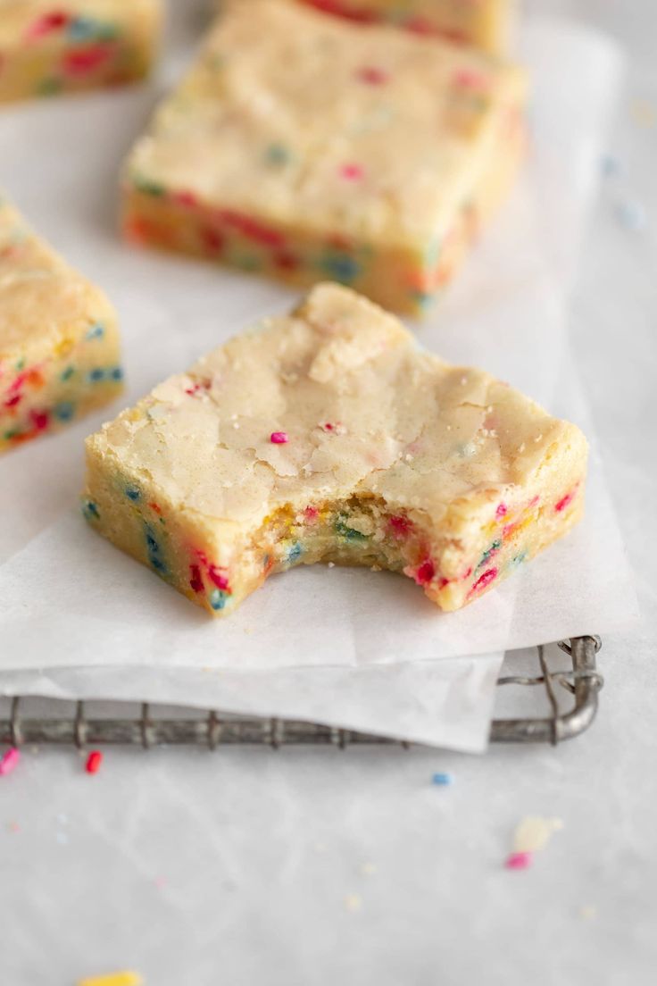 white chocolate and sprinkles are on top of some parchment paper next to a fork