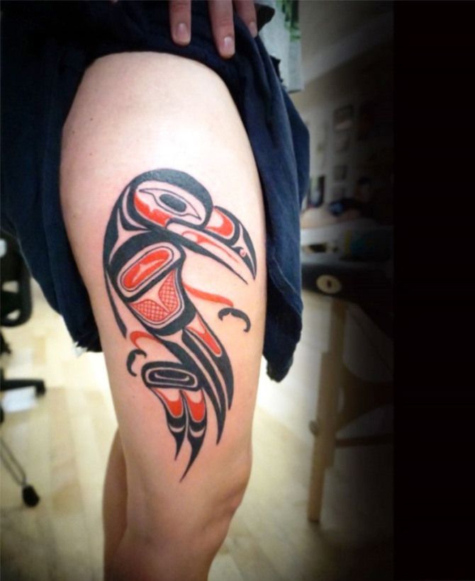 a tattoo on the leg of a woman with an eagle and totema design