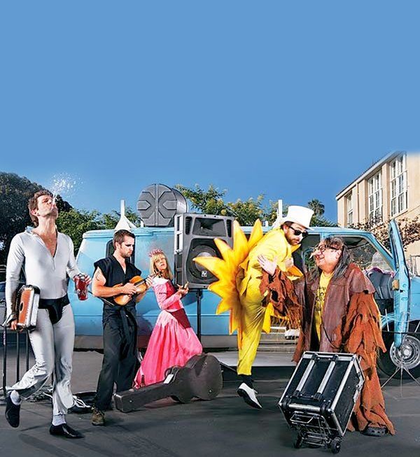 several people dressed in costumes are posing for a photo with suitcases and bananas on the street