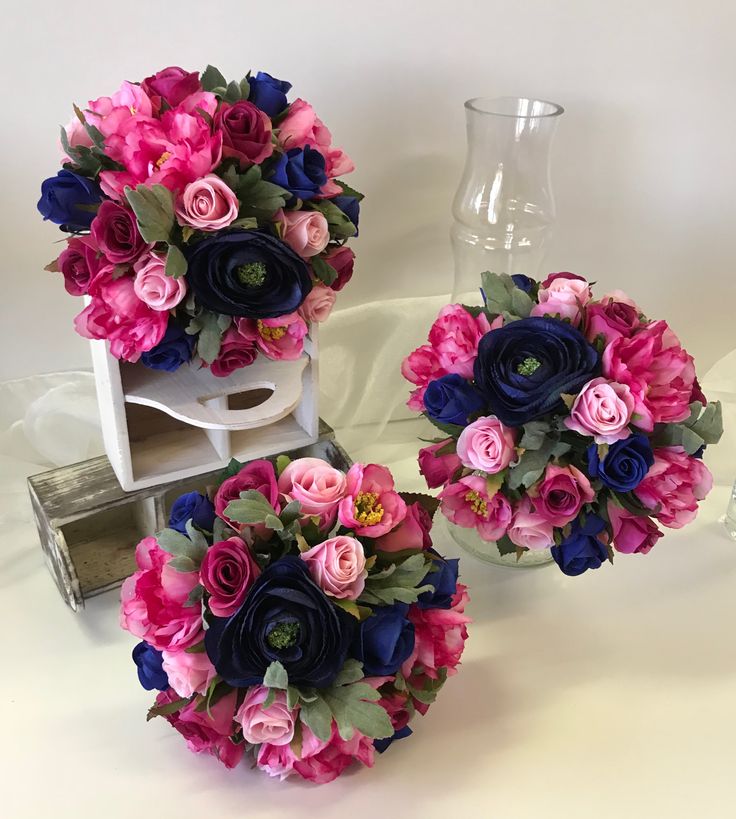 three bouquets of flowers sitting on top of a table