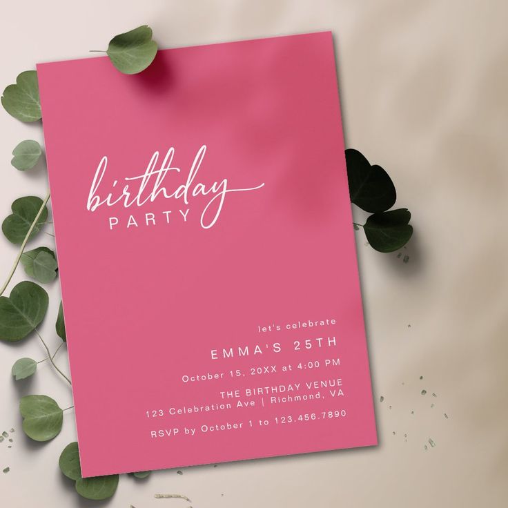 a pink birthday party card sitting on top of a table next to some green leaves