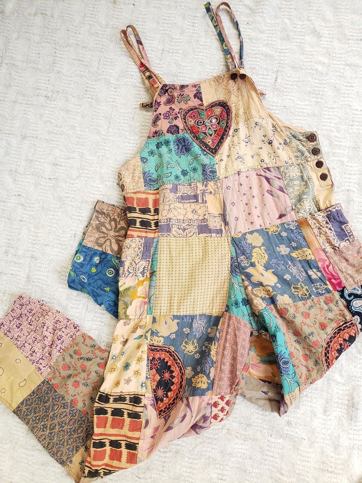 an old patchwork dress is laying on the bed next to it's matching shorts