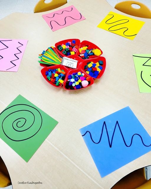 a child's table with paper cut out and colored shapes on it